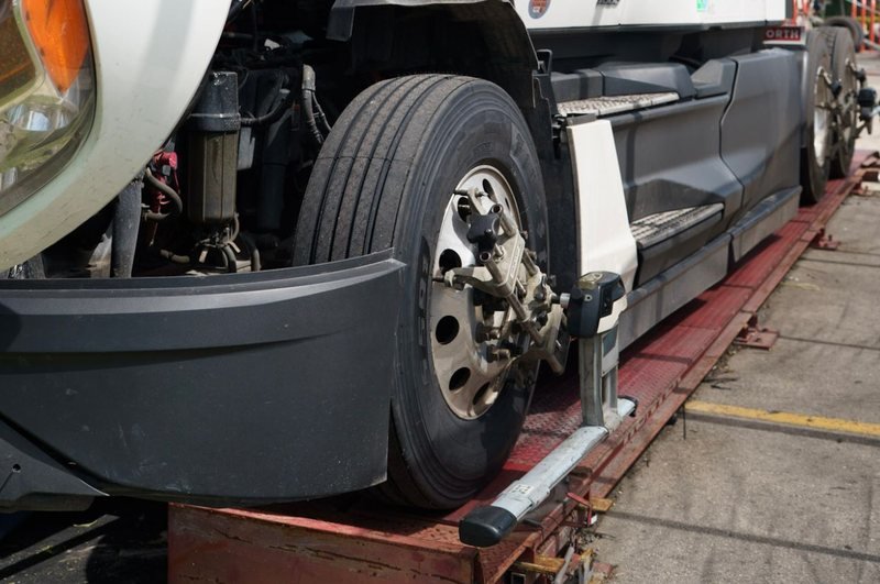 Tractocamión Kenworth en la rampa de alineación de Alex Truck Tire con sensores computarizados en las ruedas de dirección