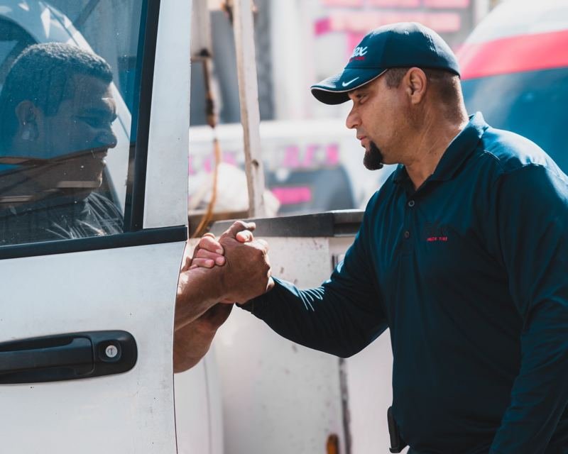Técnico de Alex Truck Tire saludando a un conductor