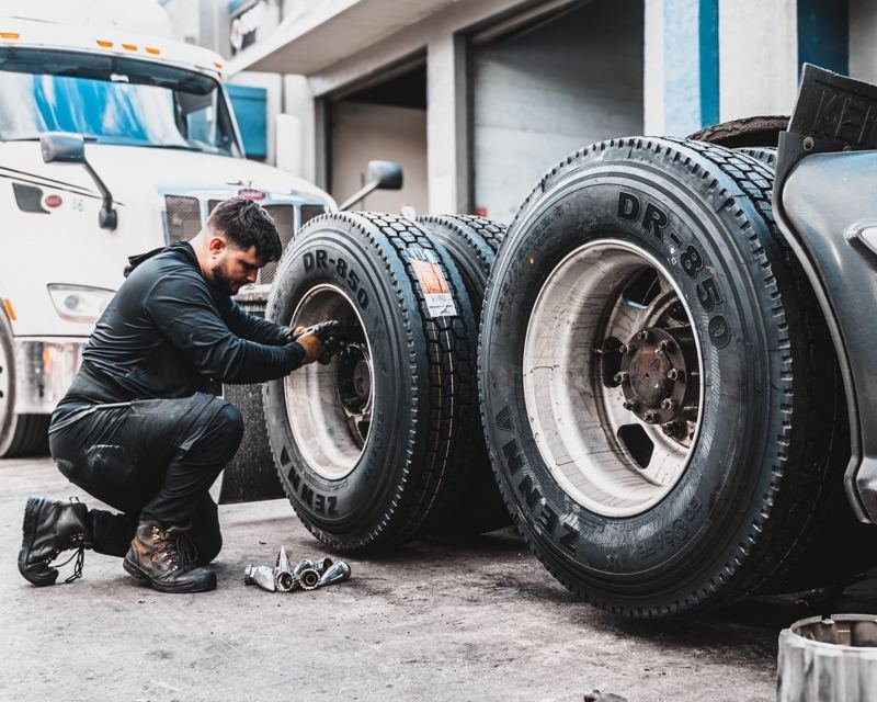 Técnico instalando neumáticos en un tractocamión
